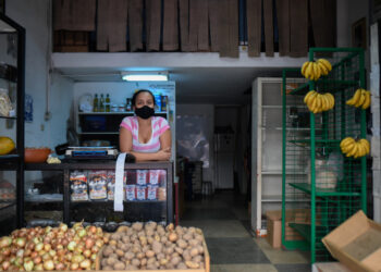 An employee waits for customers at a photography store now selling food, due to the COVID-19 coronavirus pandemic, in Chacao neighborhood in Caracas on July 15, 2020, amid the coronavirus pandemic. - The COVID-19 pandemic, which reached Venezuela in mid-March and has infected some 10,000 people, according to official figures, forced the closure of 90% of the businesses in the Caribbean country, according to the private company Consecomercio. Only supermarkets, pharmacies and other businesses considered "essential" by the socialist government are exempted from the national quarantine, which has been tightened in Caracas due to the spread of the virus. (Photo by Federico PARRA / AFP)