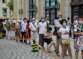 People line up to undergo COVID-19 coronavirus tests at a makeshift testing center in Dalian, in China's northeast Liaoning province on July 27, 2020. - China recorded 61 new coronavirus cases on July 27 -- the highest daily figure since April -- propelled by clusters in three separate regions that have sparked fears of a fresh wave. (Photo by STR / AFP) / China OUT
