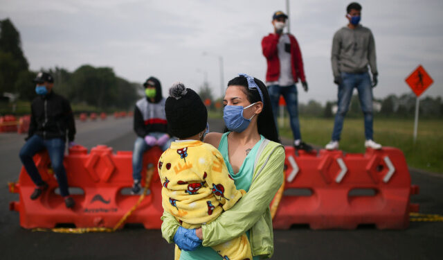 Migrantes venezolanos utilizando mascarillas participan en una protesta contra el bloqueo de los autobuses que contrataron para llegar a la frontera colombiana-venezolana, en medio del brote de la enfermedad por coronavirus (COVID-19) en Bogotá, Colombia, 29 de abril de 2020. REUTERS / Luisa Gonzalez