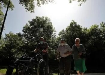 Dos personas mayores y un acompañante caminan por el paseo del Arga, en la localidad navarra de Huarte. EFE Jesús Diges.