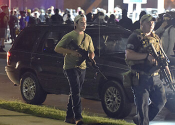 Kyle Rittenhouse, left, with backwards cap, walks along Sheridan Road in Kenosha, Wis., Tuesday, Aug. 25, 2020, with another armed civilian. Prosecutors on Thursday, Aug. 27, 2020 charged Rittenhouse, a 17-year-old from Illinois in the fatal shooting of two protesters and the wounding of a third in Kenosha, Wisconsin, during a night of unrest following the weekend police shooting of Jacob Blake. (Adam Rogan/The Journal Times via AP)