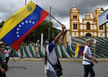 Venezuela's opposition supporters march with a Venezuelan national flag from the UN development program headquarters to the Military Counterintelligence General Directorate (DGCIM) headquarters in Caracas on July 5, 2019, during the anniversary of the Venezuelan Independence. (Photo by Yuri CORTEZ / AFP)