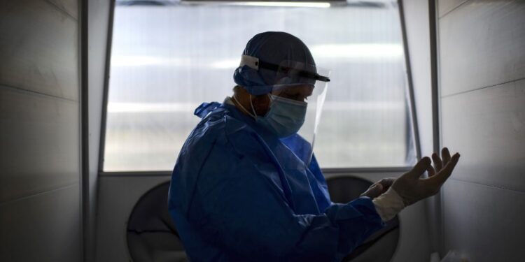 A doctor gets ready to take a swab sample through a protection system at the Professor Alejandro Posadas National Hospital in the municipality of El Palomar, province of Buenos Aires, on September 18, 2020, amid the COVID-19 novel coronavirus pandemic. - The pandemic has killed at least 946,727 people worldwide, including more than 12,000 in Argentina, since emerging in China late last year, according to an AFP tally at 1100 GMT Friday based on official sources. (Photo by Ronaldo SCHEMIDT / AFP)