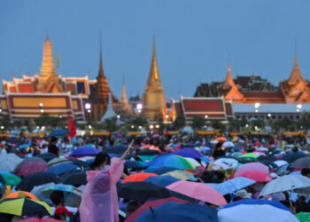 Anti-government protesters gather in Sanam Luang during a pro-democracy rally in Bangkok on September 19, 2020, as the Grand Palace is seen in the background. - Pro-democracy protesters took to the streets of Bangkok on September 19 as a rally expected to draw tens of thousands of people kicked off calling for PM Prayut Chan-O-Cha to step down and demanding reforms to the monarchy. (Photo by Mladen ANTONOV / AFP)