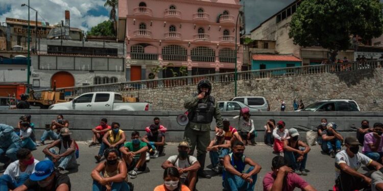 Un oficial de seguridad en Caracas, Venezuela, en julio. El personal de la Guardia Nacional detiene a los ciudadanos durante horas para explicar la importancia de cumplir con las medidas de cuarentena. | Crédito Adriana Loureiro Fernandez para The New York Time