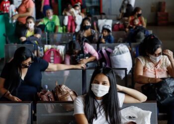 Viajeros son vistos hoy en la Terminal de Ómnibus de Asunción. EFE/Nathalia Aguilar