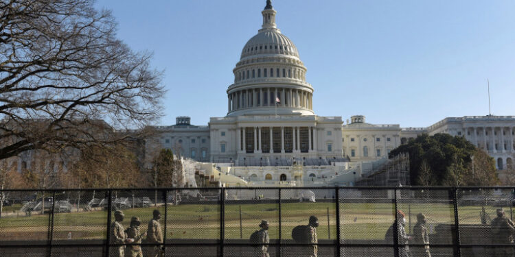 Miembros de la Guardia Nacional caminan detrás de una valla instalada frente al Congreso de Estados Unidos, un día después de que  partidarios del presidente Donald Trump ocuparon el edificio, en Washington. 7 de enero de 2021. REUTERS/Stephanie Keith