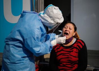 Un trabajador de la salud le practica una prueba para covid-19 a una mujer en la ciudad Villa Fiorito en la provincia de Buenos Aires (Argentina). EFE/Juan Ignacio Roncoroni/Archivo