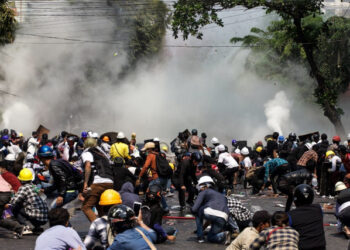 Protesters react after police fired tear gas during a demonstration against the military coup in Mandalay on March 3, 2021. (Photo by STR / AFP)