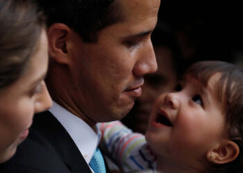 Venezuelan opposition leader and self-proclaimed interim president Juan Guaido pauses as he speaks to the media next to his wife Fabiana Rosales, while carrying their daughter outside their home after a meeting with supporters to present a government plan of the opposition in Caracas, Venezuela January 31, 2019. REUTERS/Carlos Barria