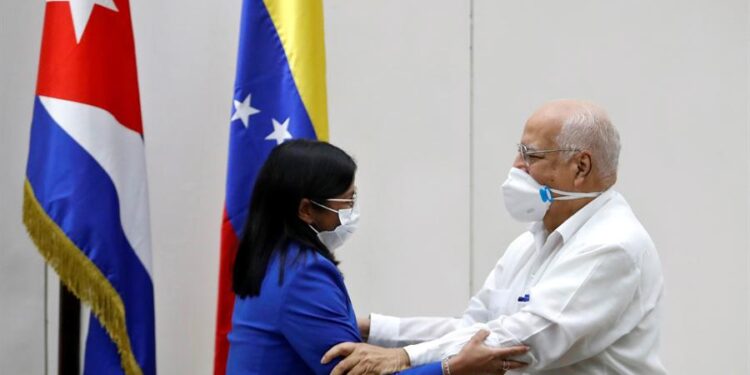 Delcy Rodríguez (i), y el viceprimer ministro de Cuba, Ricardo Cabrisas, estrechan brazos tras la firma de un convenio entre ambos países hoy, en La Habana (Cuba). Rodríguez visita la isla en el marco de la XXI Comisión Mixta Intergubernamental Cuba-Venezuela, con la que ambas naciones buscan fortalecer lazos de unión y acuerdos. EFE/ Yander Zamora