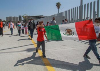 Familias de migrantes marchan hoy en las inmediaciones del cruce fronterizo de El Chaparral, en Tijuana (México). Con una sesión de oración, de la religión católica, un centenar de migrantes centroamericanos pidieron este miércoles en la ciudad de Tijuana la intercesión de Dios para que los "ayude" con la apertura de la frontera de Estados Unidos. Las plegarias de los migrantes se extendieron por poco más de una hora, tiempo en el que elevaron su voz y recordaron que su compañero en su travesía ha sido Dios, en quien expresaron su confianza para que el presidente Joe Biden cumpla la promesa de abrir las fronteras. EFE/Joebeth Terríquez