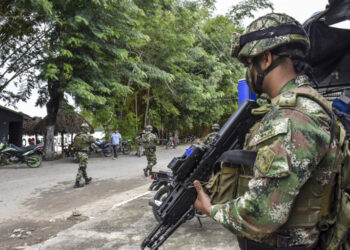 Colombian soldiers patrol near the Arauca river in Arauquita municipality, Arauca department, Colombia on March 25 , 2021. - More than 3,000 people fled to Colombia to escape fighting that broke out over the weekend in Venezuela between its military and suspected FARC dissidents, officials in Bogota said Wednesday. Venezuela's military clashed with the group near the border with Colombia on Sunday, resulting in the death of two military personnel and the capture of 32 Colombian "insurgents," according to Venezuela's Armed Forces. (Photo by Daniel Fernándo MARTINEZ CERVERA / AFP)