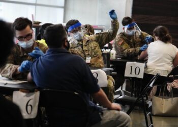 U.S. Department of Defense members administer vaccines to people at Mercedes-Benz Stadium on Thursday, March 25, 2021, in Atlanta. Gov. Brian Kemp said all Georgians 16 and older will be eligible to receive the COVID-19 vaccine. (AP Photo/Brynn Anderson)