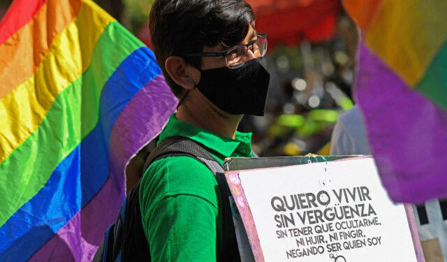 (FILES) In this file photo taken on February 11, 2021 a member of the Venezuelan LGBTI (lesbian, gay, bi-sexual, transsexual and intersex) community takes part in a demonstration demanding marriage equality while holding a signal that reads "I want to live without shame", in front of the National Assembly building in Caracas. - LGBTI organizations in Venezuela, which is behind in the line of Latin American countries in terms of rights of the LGBTI community, are pushing for the new Parliament to discuss an equal marriage law in 2021. (Photo by Federico PARRA / AFP)