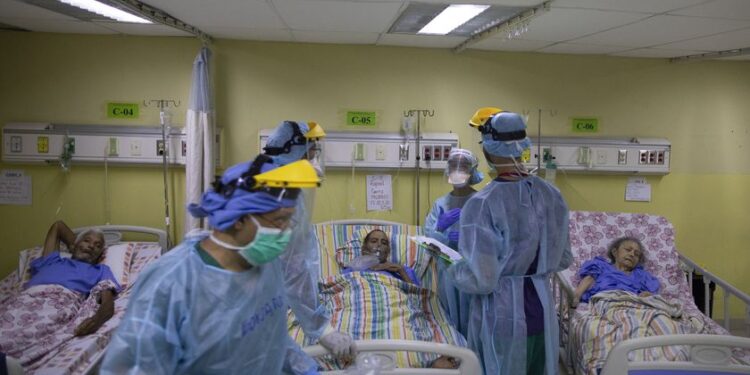 Venezuelan health workers with Doctors Without Borders attend COVID-19 patients at the PerÃ©z de LeÃ³n II Hospital, a public hospital in the Petare neighborhood of Caracas, Venezuela, Monday, Sept. 22, 2020. The wing is staffed with 120 doctors, nurses and technicians who care for 36 patients, including six in intensive care connected to respirators and under sedation. (AP Photo/Ariana Cubillos)