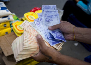 A man holds Bolivar bills a street market in Caracas' Catia neighborhood, on April 6, 2021, amid the Covid-19 pandemic. (Photo by Pedro Rances Mattey / AFP)