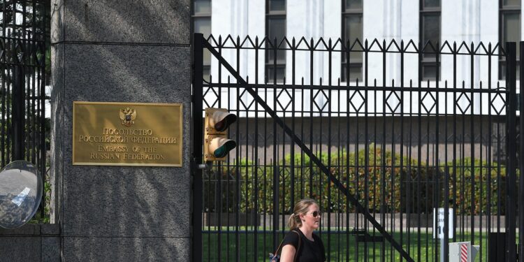 A pedestrian is seen in front of the Embassy of Russia in Washington, DC on April 15, 2021. - The US announced sanctions against Russia on April 15, 2021, and the expulsion of 10 diplomats in retaliation for what Washington says is the Kremlin's US election interference, a massive cyber attack and other hostile activity. President Joe Biden ordered a widening of restrictions on US banks trading in Russian government debt, expelled 10 diplomats who include alleged spies, and sanctioned 32 individuals alleged to have tried to meddle in the 2020 presidential election, the White House said. (Photo by MANDEL NGAN / AFP)