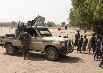 Soldiers of the Chad Army stand next to a Land Cruiser, while bystanders look on, before buing sheep at the Koundoul market, 25 km from N'Djamena, on January 3, 2020, upon their return  after a months-long mission fighting Boko Haram in neighbouring Nigeria. - Chad has ended a months-long mission fighting Boko Haram in neighbouring Nigeria and withdrawn its 1,200-strong force across their common border, an army spokesman told AFP on January 4, 2020. (Photo by - / AFP)