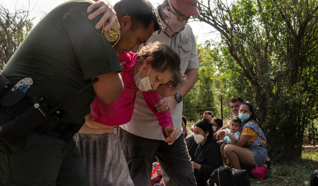 An U.S. Border Patrol agent assists an elderly asylum-seeking migrant woman from Venezuela after the woman crossed the Rio Grande river into the United States from Mexico in Del Rio, Texas, U.S., May 26, 2021. REUTERS/Go Nakamura