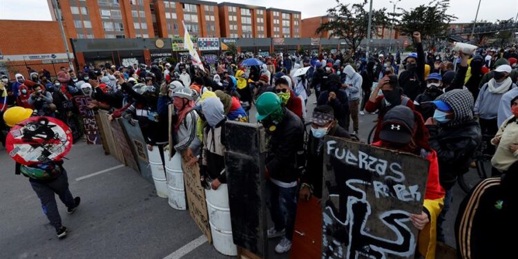 Manifestantes utilizan hoy escudos improvisados durante una protesta en el día 13 del Paro Nacional contra el Gobierno de Iván Duque, en Bogotá (Colombia). La reunión del presidente colombiano, Iván Duque, y del Comité Nacional de Paro culminó este lunes sin acuerdos, por lo que fue convocada una nueva jornada de manifestaciones para el miércoles. "El Gobierno en los dos temas centrales que se plantearon sobre las garantías de las protestas y sobre el cese a la actuación desmedida de la fuerza pública contra la gente (...) no dijo nada en concreto", expresó a Efe el secretario general de la Central Unitaria de Trabajadores de Colombia (CUT), Diógenes Orjuela. EFE/ Mauricio Dueñas Castañeda