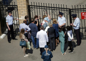 People gather by the fence of School No. 175 following a shooting in Kazan on May 11, 2021. (Photo by Roman Kruchinin / AFP)