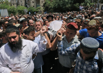 Israeli mourners attend the funeral of Yehuda Gueta, a 19-year-old Yeshiva student, in Jerusalem on May 6, 2021, after succumbed to his wounds following a Palestinian drive-by shooting attack earlier this week in the occupied West Bank. - Suspected Palestinian gunmen carried out a drive-by shooting at a nearby junction the previous, leaving three Israeli civilians wounded, one of them in critical condition. (Photo by Menahem KAHANA / AFP)