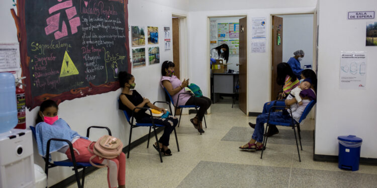 Women keep safety distances among them as they wait to see a doctor at a clinic of the organization Doctors Without Borders (MSF) installed in Barcelona, Anzoategui State, Venezuela, on March 16, 2021. - The NGO Doctors Without Borders is giving free contraceptive methods, mostly for teenagers, in a country where they have prohibitively high prices. (Photo by Pedro Rances Mattey / AFP)