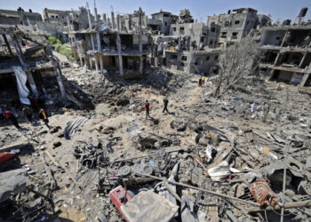 TOPSHOT - Palestinians assess the damage caused by Israeli air strikes, in Beit Hanun in the northern Gaza Strip, on May 14, 2021. - Israel pounded Gaza and deployed extra troops to the border as Palestinians fired barrages of rockets back, with the death toll in the enclave on the fourth day of conflict climbing to over 100. (Photo by MAHMUD HAMS / AFP)