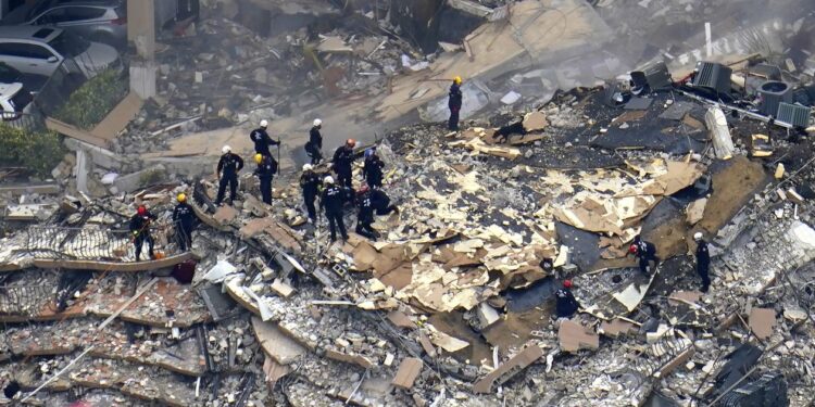 Rescue workers search in the rubble at the Champlain Towers South Condo, Friday, June 25, 2021, in Surfside, Fla. The seaside condominium tower collapsed on Thursday. (AP Photo/Gerald Herbert)