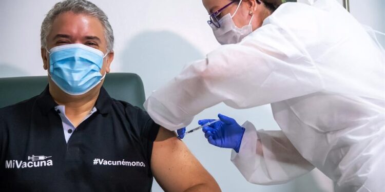 Fotografía cedida por la Presidencia de Colombia que muestra al mandatario Iván Duque mientras recibe la vacuna Pfizer contra la covid-19 hoy, en Bogotá (Colombia). El presidente de Colombia, Iván Duque, recibió este domingo la primera dosis de la vacuna de Pfizer en el Hospital Militar de Bogotá. En el país, que atraviesa su peor momento de la pandemia, ya han sido aplicados 12'917.941 de inmunizantes, informaron fuentes oficiales. EFE/ Presidencia De Colombia