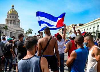 Cubans are seen outside Havana's Capitol during a demonstration against the government of Cuban President Miguel Diaz-Canel in Havana, on July 11, 2021. - Thousands of Cubans took part in rare protests Sunday against the communist government, marching through a town chanting "Down with the dictatorship" and "We want liberty." (Photo by YAMIL LAGE / AFP)