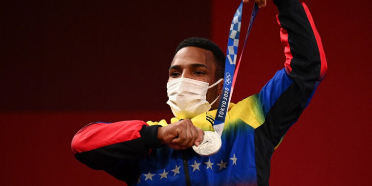 Silver medallist Venezuela's Julio Ruben Mayora Pernia poses on the podium for the victory ceremony of the men's 73kg weightlifting competition during the Tokyo 2020 Olympic Games at the Tokyo International Forum in Tokyo on July 28, 2021. (Photo by Vincenzo PINTO / AFP)