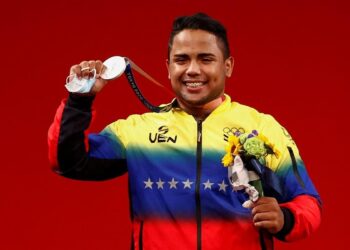 El venezolano Keydomar Giovanni Vallenilla Sanchez celebra en el podio tras conseguir la medalla de plata en la prueba de levantamiento de pesas masculino de 96 kg durante los Juegos Olímpicos 2020, este sábado en el Foro Internacional de Tokio (Japón). EFE/José Méndez