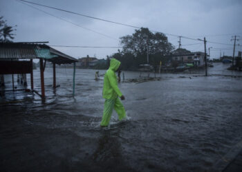 A man walks in a flooded street due to heavy rains caused by Hurricane Grace in Tecolutla, Veracruz, Mexico, on August 21, 2021. - Hurricane Grace lashed eastern Mexico with heavy rain and strong wind on Saturday, causing flooding, power blackouts and damage to homes as it gradually lost strength over the mountainous interior. (Photo by VICTORIA RAZO / AFP)