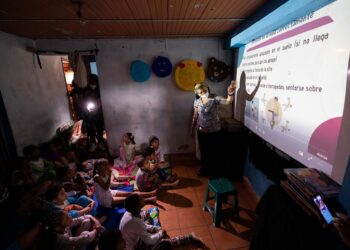 Un grupo de niños toma una clase de postura correcta en la casa familiar de la maestra Milagros Agreda, el 20 de agosto de 2021, en Petare, Caracas (Venezuela). Maestras preocupadas por la educación de los niños que habitan en Petare, una de las barriadas más pobres de Venezuela, abrieron las puertas de sus casas para educar a los chicos en medio del cierre de escuelas, empujado por la covid-19, que ya suma más de un año y el difícil acceso a internet. EFE/ RAYNER PEÑA R.