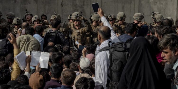 Un hombre sujeta su pasaporte delante de los militares que guardan el aertopuerto de Kabul. JUAN CARLOS