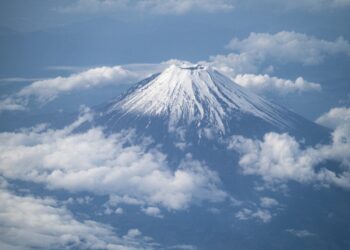 This picture shows Mount Fuji, Japan's highest mountain at 3,776 meters (12,388 feet), seen from the window of a passenger aircraft en route to Kagoshima on May 14, 2021. (Photo by Charly TRIBALLEAU / AFP)