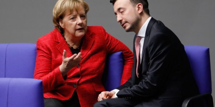 German Chancellor Angela Merkel talks with Paul Ziemiak, leader of her Christian Democratic Union (CDU) party's youth organisation Junge Union, during a session at the Bundestag (lower house of parliament) on November 21, 2017 in Berlin. / AFP PHOTO / Odd ANDERSEN