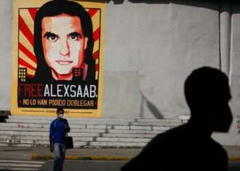 People walk past graffiti in favor of the release of Colombian businessman Alex Saab, amidst the Coronavirus pandemic, on the west side of the city in Caracas, Venezuela on September 8, 2021. (Photo by Javier Campos/NurPhoto)