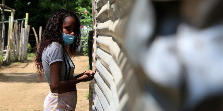 Una mujer migrante entra a su casa hoy, en la comunidad 7 de Mayo, en Malagana (Colombia). Unas 334 personas, entre colombianos y venezolanos, viven desde hace año y medio en la comunidad 7 de Mayo, un asentamiento conformado por viviendas precarias hechas de plástico, maderas viejas y láminas de zinc en la región Caribe del país andino. Esta comunidad se erigió hace año y medio en un lote del corregimiento (pueblo) de Malagana, a unos 45 kilómetros de la turística Cartagena de Indias. EFE/ Ricardo Maldonado Rozo