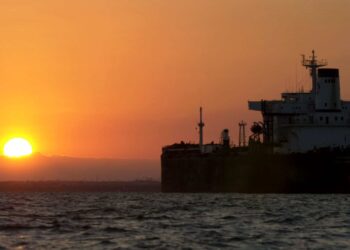 An oil tanker is silhouetted as the sun rises over Lake Maracaibo, Venezuela, on Friday, December 13, 2002.