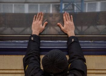 Aleksander, de 41 años, aprieta las palmas de las manos contra la ventanilla mientras se despide de su hija Anna, de 5 años, en un tren hacia Lviv en la estación de Kiev, Ucrania, el viernes 4 de marzo de 2022.