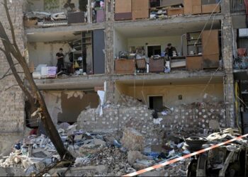 Residentes recuperan lo que queda en sus apartamentos destruidos, ubicados en un edificio residencial de cinco pisos que se derrumbó parcialmente después de los bombardeos del día anterior por parte de las tropas rusas en Kyiv. Crédito: SERGEI SUPINSKY/AFP a través de Getty Images