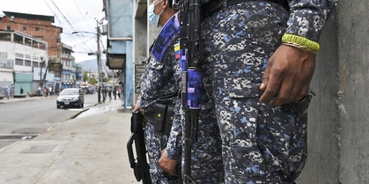 Members of the Bolivarian National Police stand guard at a checkpoint during a confrontation with alleged criminal gangs at the La Vega neighborhood in Caracas on May 24, 2021. (Photo by Yuri CORTEZ / AFP)