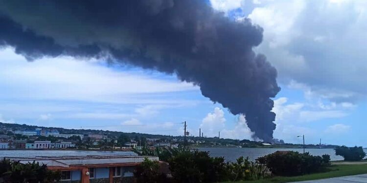 Fotografía de una columna de humo generada por el incendio en un depósito de combustible hoy, en Matanzas (Cuba). El Ministerio de Salud Pública de Cuba (Minsap) confirmó este sábado la muerte de una persona por el incendio que sigue activo en dos de los ocho depósitos de crudo en la provincia de Matanzas (occidente). EFE/ Ernesto Mastrascusa