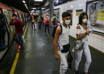People travel on the subway wearing protective masks as a preventive measure in the face of the global COVID-19 coronavirus pandemic, in Caracas, on March 14, 2020. - Venezuela requires a 'mandatory quarantine' for all travelers from Europe who arrived in the country in March, one day after confirming their first two cases of coronavirus. (Photo by Cristian Hernandez / AFP)