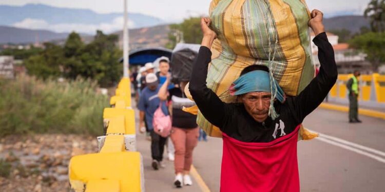 Varias personas cruzan el Puente Simón Bolivar, que conecta la frontera de Venezuela con Colombia, hoy, en San Antonio (Venezuela). Colombia y Venezuela vuelven a estar unidas por la frontera común que se ha reabierto este lunes, tras siete largos años que acentuaron las diferencias de dos países, cuyos intereses políticos primaron sobre la economía común, la seguridad compartida o el bienestar social de compatriotas residentes o migrantes en la nación de enfrente. EFE/ Rayner Peña R.