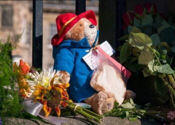 Los jardineros de la realeza fueron retirando de a poco el envoltorio de plástico de las flores colocadas, mientras que el público también han colaborado (Jane Barlow/PA via AP).