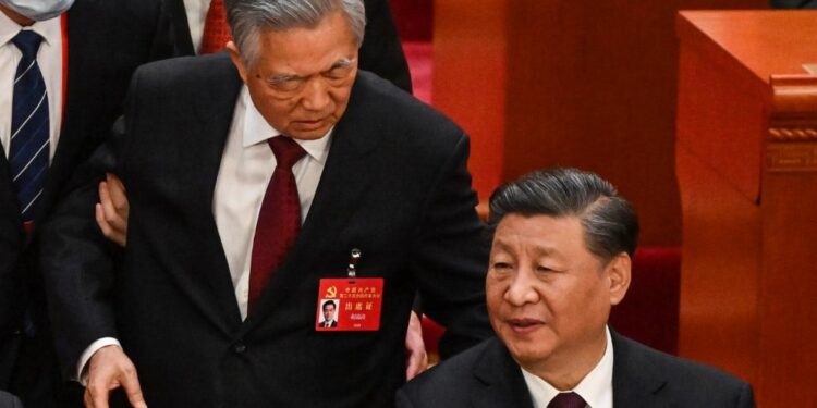 China's President Xi Jinping (R) talks to former president Hu Jintao as he is assisted to leave from the closing ceremony of the 20th Chinese Communist Party's Congress at the Great Hall of the People in Beijing on October 22, 2022. (Photo by Noel CELIS / AFP)